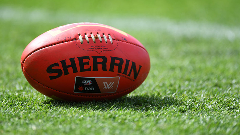 Australian rules football on grass playing field