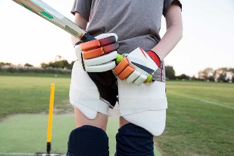 Close up of female cricketer wearing gloves and pads