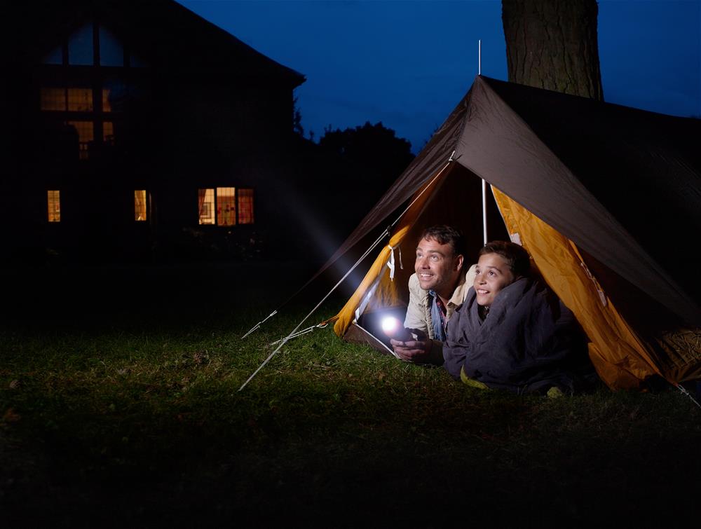 Father and child camping in backyard