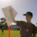 A boy holding up a kite he made