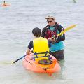 An instructor assisting a participant on a kayak