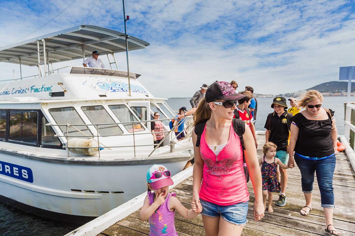 Families walking off a boat and onto the jetty