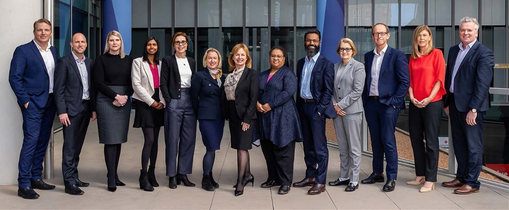 A group of people standing in a line wearing office attire